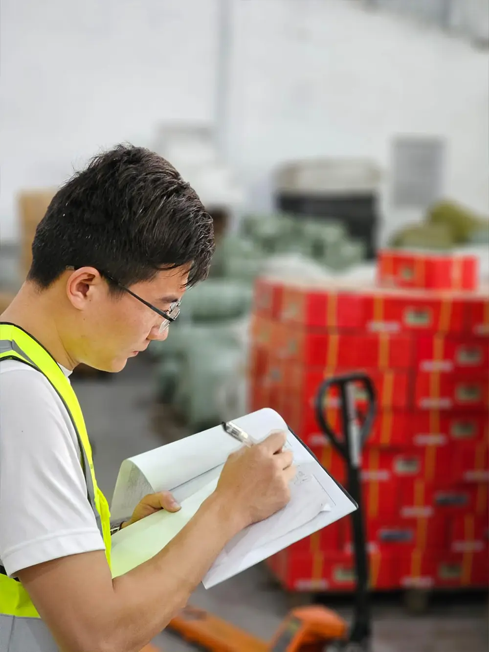 Chinese man working for UG Shipping writing notes